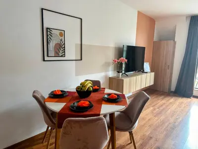 a dining room with a table and chairs and a television at Grace Appartament in Plovdiv