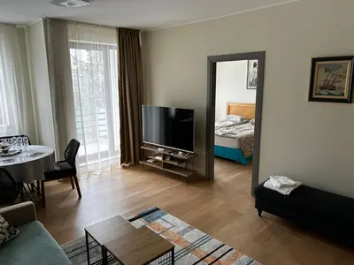 a living room with a couch and a television and a bed at Silent retreat at Euphoria Club and SPA Borovets in Borovets