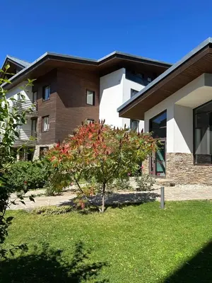 a house with a tree in front of a building at Silent retreat at Euphoria Club and SPA Borovets in Borovets