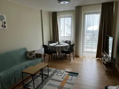 a living room with a couch and a table with chairs at Silent retreat at Euphoria Club and SPA Borovets in Borovets