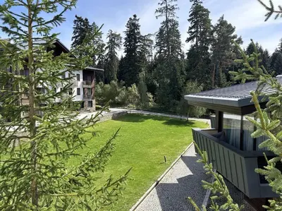 a garden with a house in the background at Silent retreat at Euphoria Club and SPA Borovets in Borovets