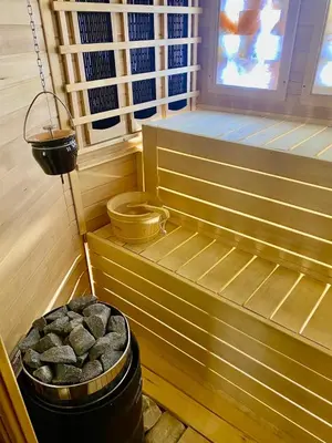 a soak room with a bucket of rocks in a sauna at Hotel Mursal in Yagodina