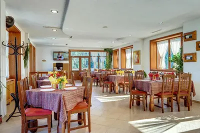 a restaurant with tables and chairs with flowers on them at Hotel Mursal in Yagodina
