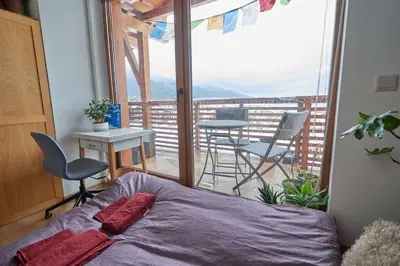 a bedroom with a bed and a balcony with a table and chairs at Panoramic 2 Bedroom Cabin Retreat Japanese Style in Bansko
