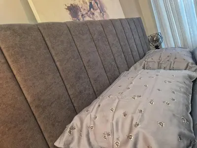 a bed with a gray headboard with flowers on it at Daisy Garden by the Church in Razlog