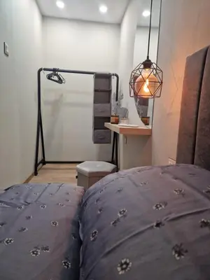a bedroom with a bed and a lamp and a table at Daisy Garden by the Church in Razlog