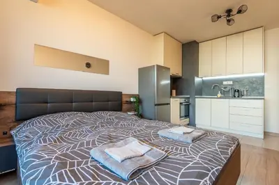 a bedroom with a large bed with two towels on it at Palitra Studio in Sofia