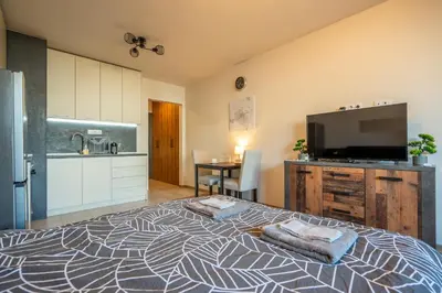 a large bedroom with a large bed and a kitchen at Palitra Studio in Sofia