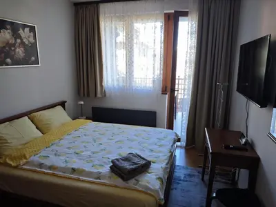 a bedroom with a bed and a desk and a television at Bansko Pirin Golf & Country Club Blue Mountains View in Razlog