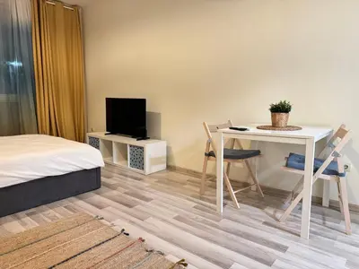 a room with a bed and a table and a tv at Studio 108 by COSHER in Sofia