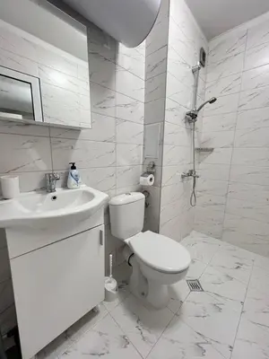 a white bathroom with a toilet and a sink at Santorini modern and cosy Apt near UNSS and NSA w WiFi in Sofia