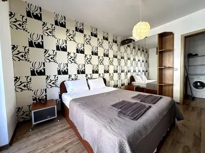 a bedroom with a bed and a wall with black and white patterns at Cozy flat in central Sofia in Sofia