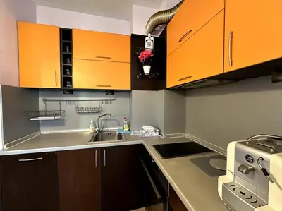 a kitchen with orange cabinets and a sink at Cozy flat in central Sofia in Sofia