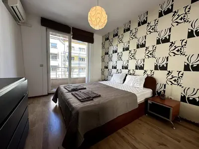a bedroom with a bed and a wall with black and white wallpaper at Cozy flat in central Sofia in Sofia