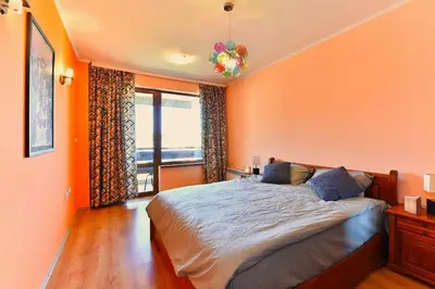 a bedroom with orange walls and a bed with a window at Cedar Lodge III - One BDRM Flat B18 in Bansko