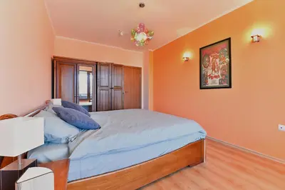 a bedroom with orange walls and a bed with blue pillows at Cedar Lodge III - One BDRM Flat B18 in Bansko