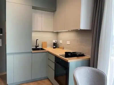a small kitchen with white cabinets and a counter top at Via421 by COSHER in Sofia
