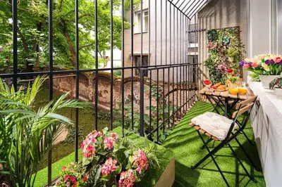 a balcony with a table and chairs and flowers at Your Spacious Home With Terrace & 3 Acs in Sofia
