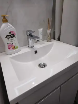 a white bathroom sink with a bottle of nelson soap at New Premium COZY apartment in the center next to NDK in Sofia
