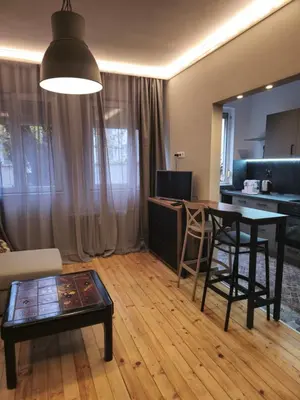 a living room with a table and a kitchen at New Premium COZY apartment in the center next to NDK in Sofia