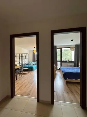 a bedroom with a bed and a living room with a table at large apartment in Borovets in Borovets