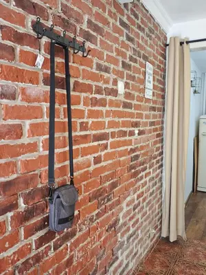 a brick wall with a black object hanging on it at Artistic Atelier, Top Center - Vitosha Blvd in Sofia