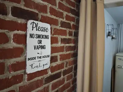 a sign on a brick wall that says no smoking or waving at Artistic Atelier, Top Center - Vitosha Blvd in Sofia