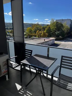 a table and chairs on a balcony with a view at Apartmenthaus Oborishte 2-3-10 in Panagyurishte