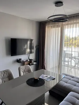 a living room with a table and a tv at Apartmenthaus Oborishte 2-3-10 in Panagyurishte