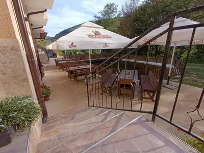 a patio with tables and umbrellas in a restaurant at Комплекс Кантона in Razhishte