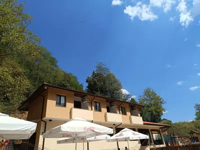 a building with umbrellas in front of it at Комплекс Кантона in Razhishte