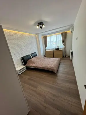 a bedroom with a bed and a brick wall at Апартамент LiAn in Plovdiv