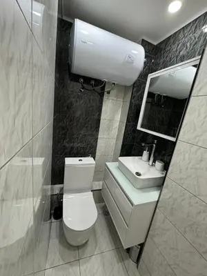 a bathroom with a toilet and a sink and a mirror at Апартамент LiAn in Plovdiv