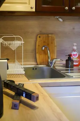 a kitchen sink with a dish drying rack next to it at Oborishte Family Elegance with Garden View in Sofia
