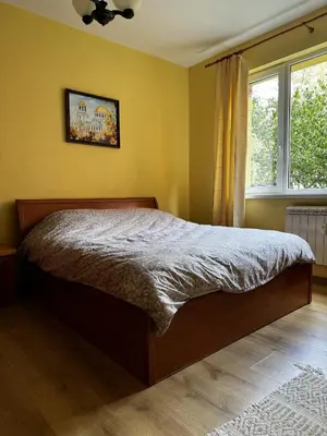 a bedroom with a bed and a window at Oborishte Family Elegance with Garden View in Sofia
