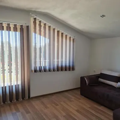 a living room with a couch and two windows at Вила Хадживезула in Yokoruda
