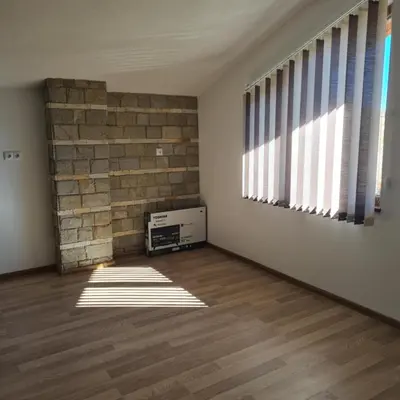 an empty room with sunlight coming through the windows at Вила Хадживезула in Yokoruda