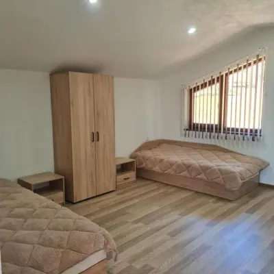 a bedroom with two beds and wooden floors at Вила Хадживезула in Yokoruda
