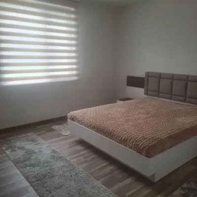 a bedroom with a bed and a window with blinds at Вила Хадживезула in Yokoruda