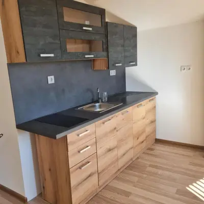 a kitchen with a sink and wooden cabinets at Вила Хадживезула in Yokoruda