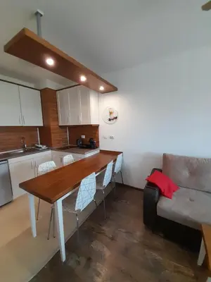 a kitchen with a wooden table and a couch at Belvedere Holiday Club H79 in Bansko