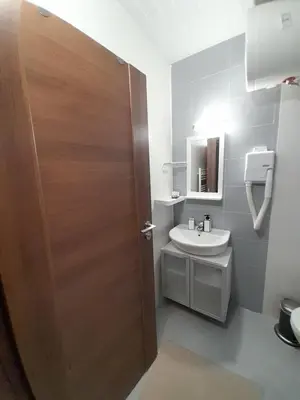 a bathroom with a wooden door and a sink at Belvedere Holiday Club H79 in Bansko