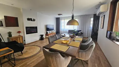 a living room with a large wooden table and chairs at MONTEVERDE Tamplier in Bansko