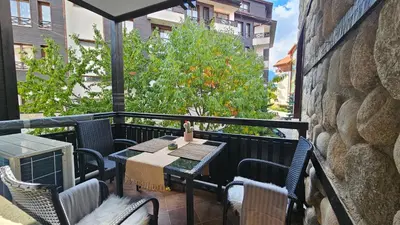 a patio with a table and chairs on a balcony at MONTEVERDE Tamplier in Bansko