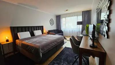 a bedroom with a bed and a desk with a computer at MONTEVERDE Tamplier in Bansko
