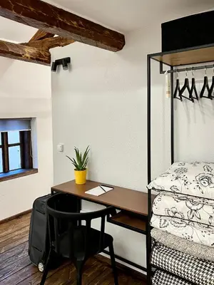 a bedroom with a desk and a bed and a bed and a chair at Туйковата къща The Tuikov House in Teteven