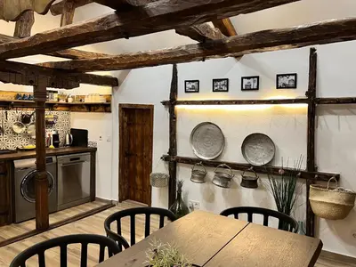 a kitchen with a wooden table and chairs at Туйковата къща The Tuikov House in Teteven