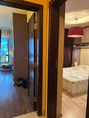 a room with a bedroom with a bed and a lamp at Luxury Apartment Bansko in Bansko