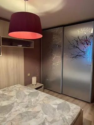a bedroom with a bed with a painting on the wall at Luxury Apartment Bansko in Bansko
