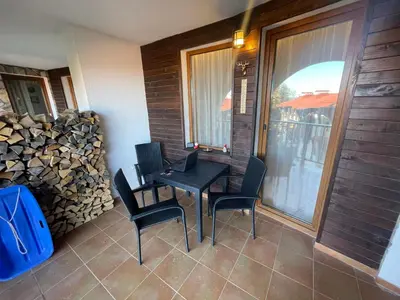 a patio with a table and chairs and a window at GS SKI Apartment - The Grand Monastery Pamporovo in Pamporovo